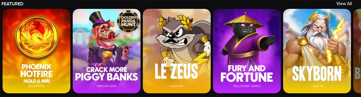“Featured” games carousel showing colourful slot tiles: Phoenix Hotfire Hold & Win, Crack More Piggy Banks, Le Zeus, Fury and Fortune, and Skyborn, with a “View All” link.