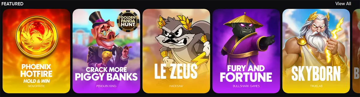 “Featured” games carousel showing colourful slot tiles: Phoenix Hotfire Hold & Win, Crack More Piggy Banks, Le Zeus, Fury and Fortune, and Skyborn, with a “View All” link.